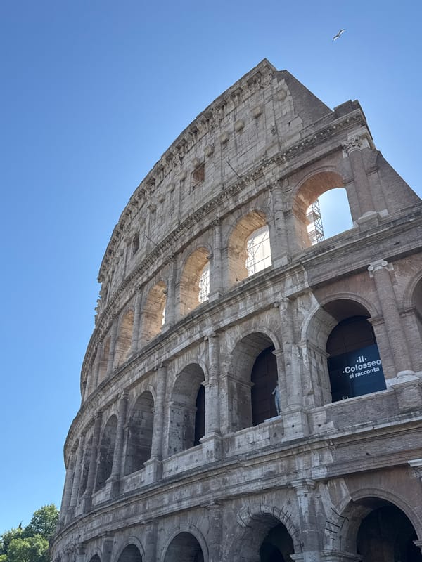 Tourist captures low-angle view of Rome's Colosseum with banner