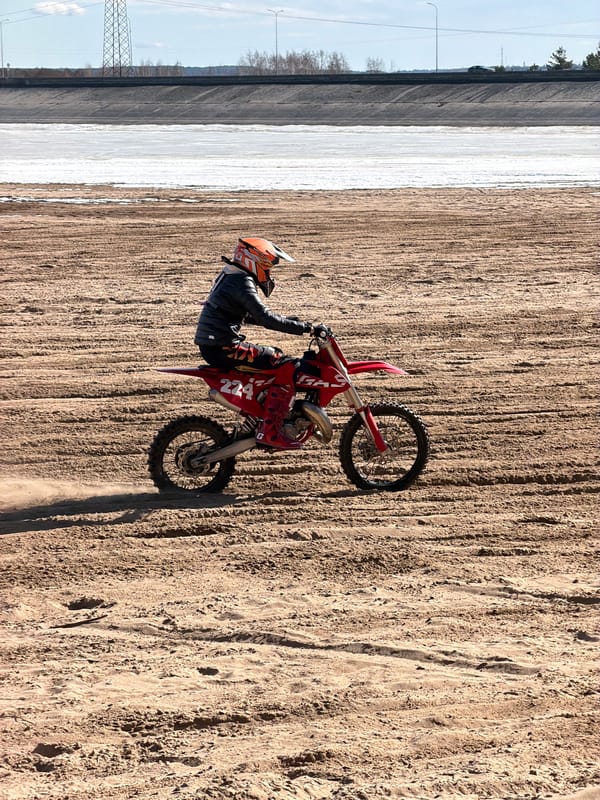 Motocross riders perform stunts near frozen river in Chaikovsky