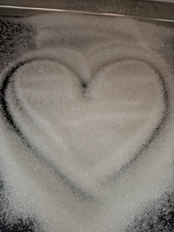 Heart drawn in sugar on dark surface in Novi Sad