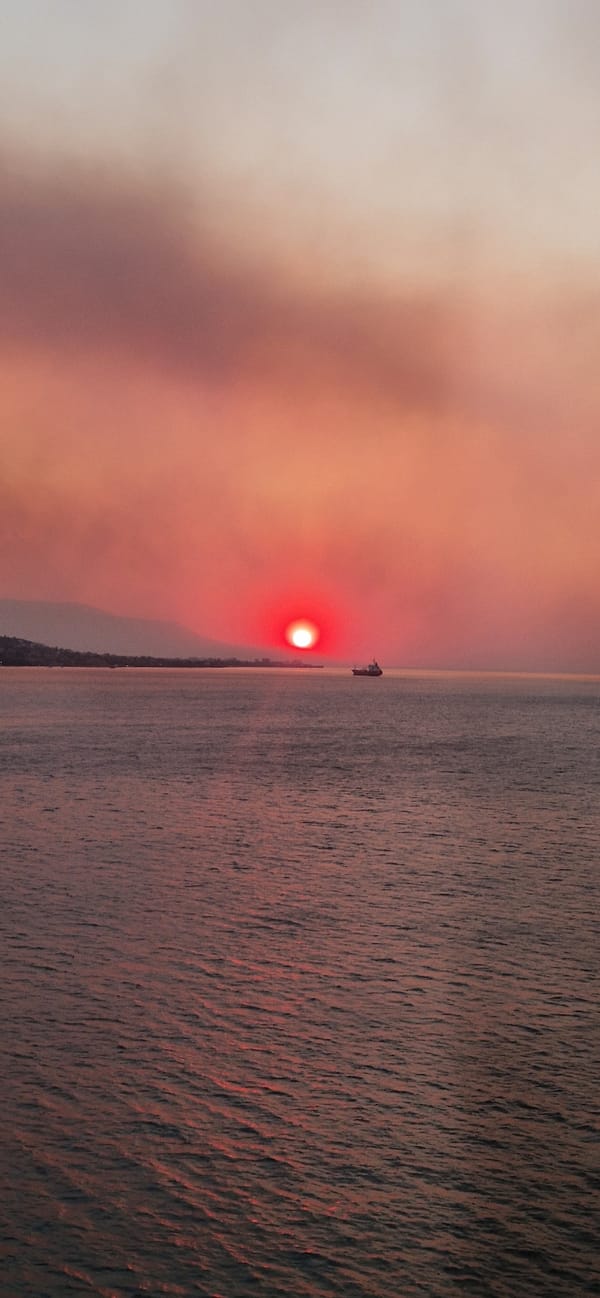 Cargo ship crosses a fiery sunset off the Greek coast