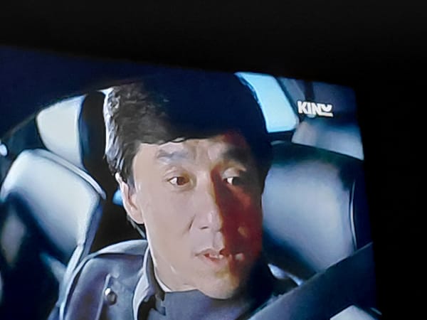 Man in suit observed in vehicle, resembles Jackie Chan