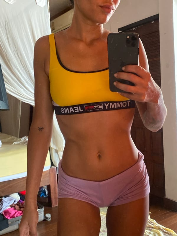 Mirror selfie session in a Ko Pha-ngan room, yellow sports bra.