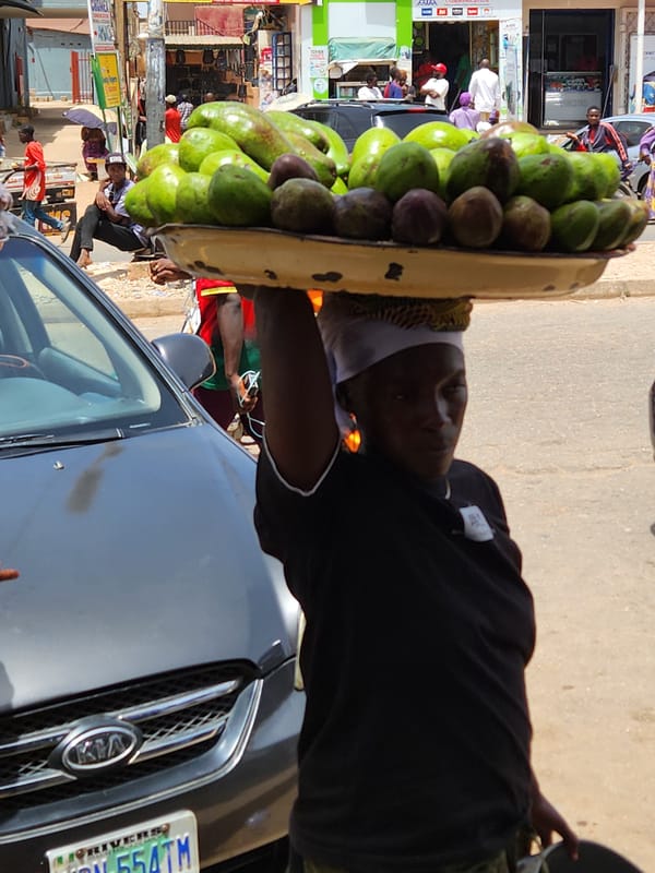 Street vendors selling fruit on busy sidewalk observed