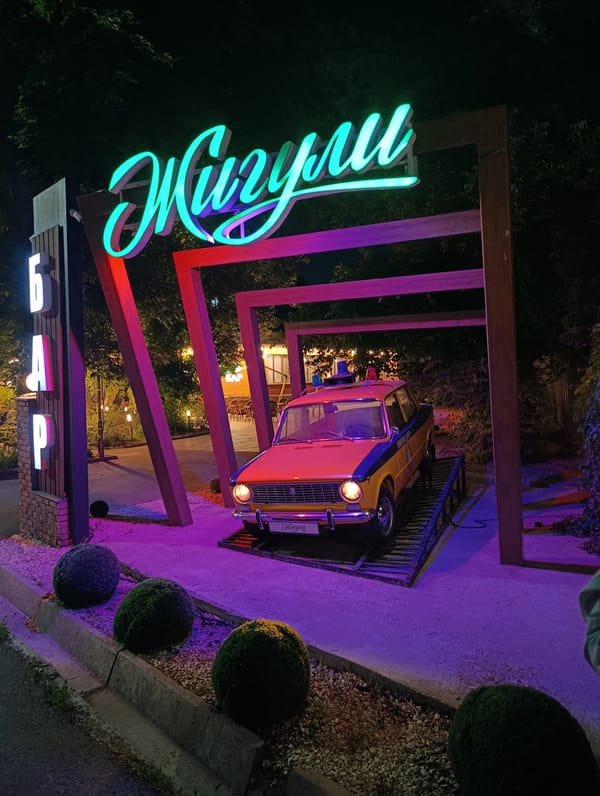 Vintage Zhiguli police car displayed at themed bar entrance