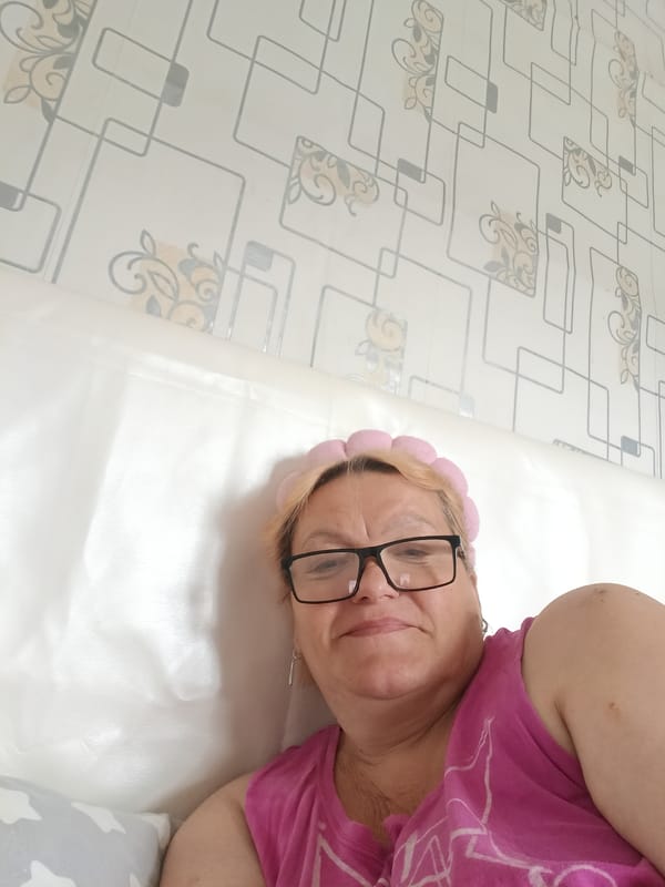Woman in pink outfit relaxes in bedroom, Красный Маяк