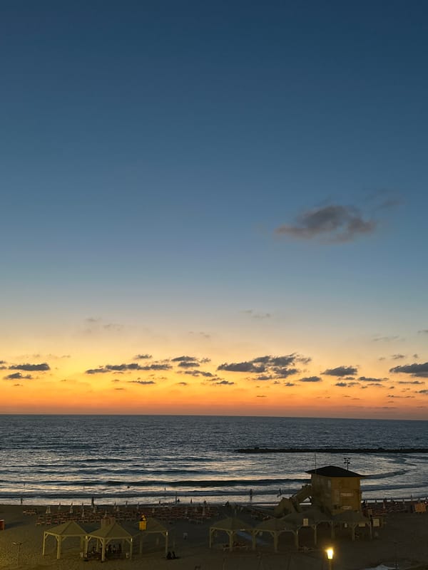 Tel Aviv beach at golden hour, sky ablaze with color