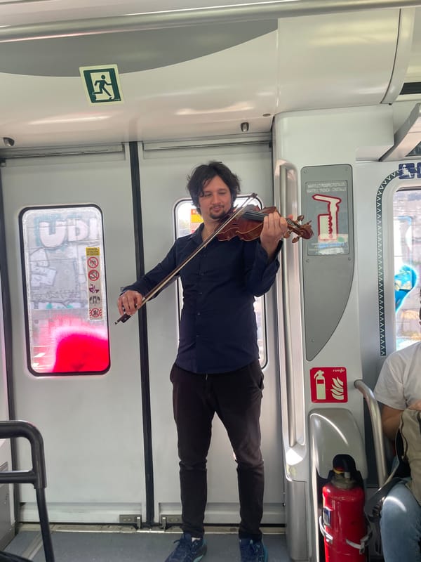 Street musician performs violin on metro train in Barcelona area