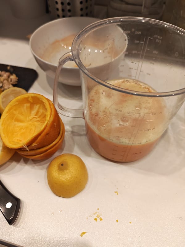 Citrus prep in the kitchen while two cats roam nearby