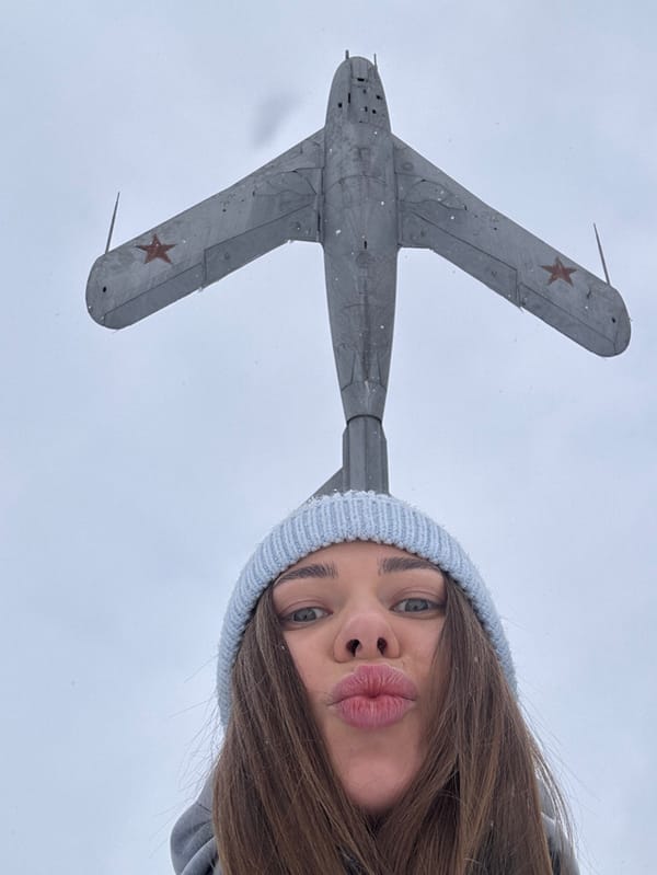 Woman photographs herself beneath MiG-15 monument in Chernushka