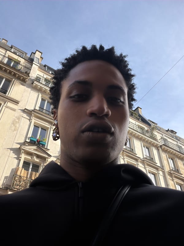 Person captures upward-gazing selfies on classic Paris street