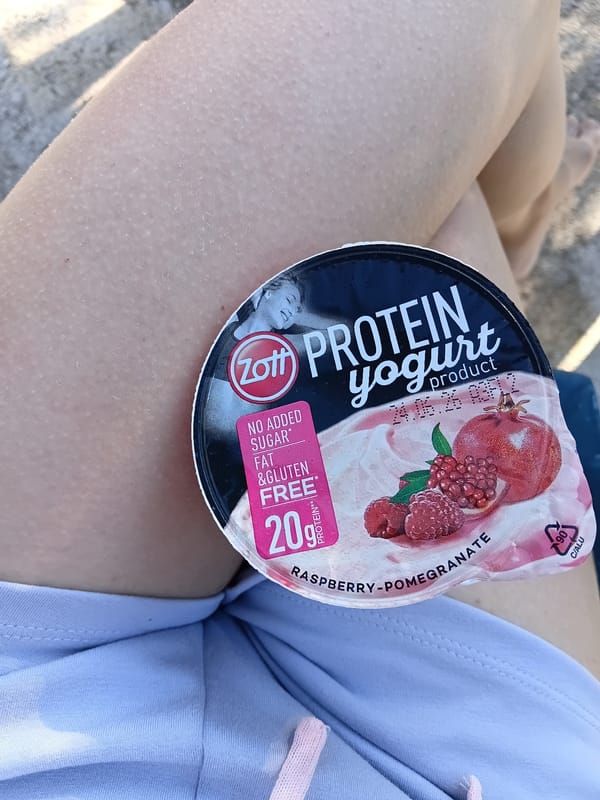 Woman rests with yogurt snack in Vlora bedroom