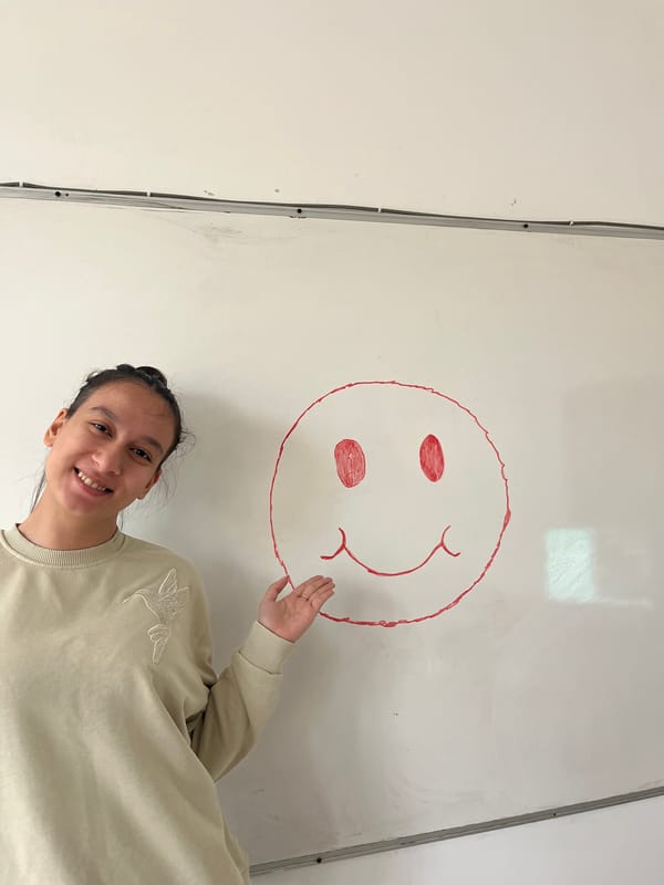 Student poses with artwork in Karnobat classroom setting
