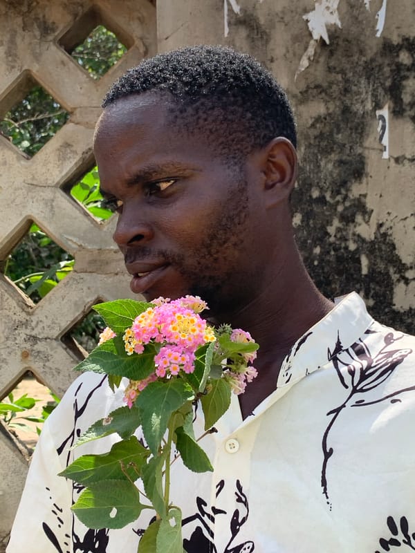 Man with flowers photographed at concrete wall in Ikorodu