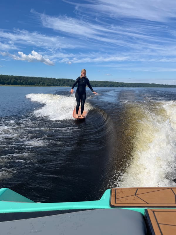 Wake surfing a calm Russian lake on a summer morning