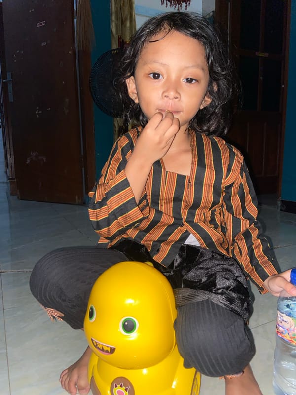 Child plays on yellow toy in Gelam, Indonesia