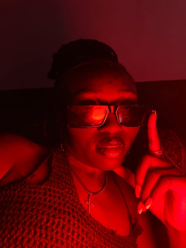 Woman relaxes on couch in colorfully lit Nigerian interior