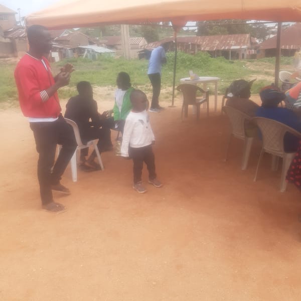 Community gathering under canopies on a dusty Jos afternoon