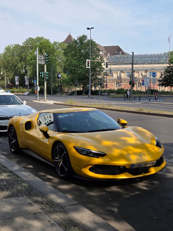Yellow Ferrari and Aston Martin parked on a Berlin street