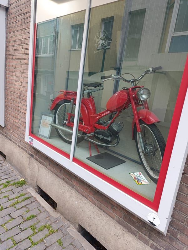 Red motorcycle displayed in German storefront window