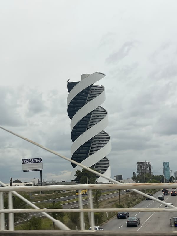 Torre Helix spiral skyscraper under cloudy skies, Puebla