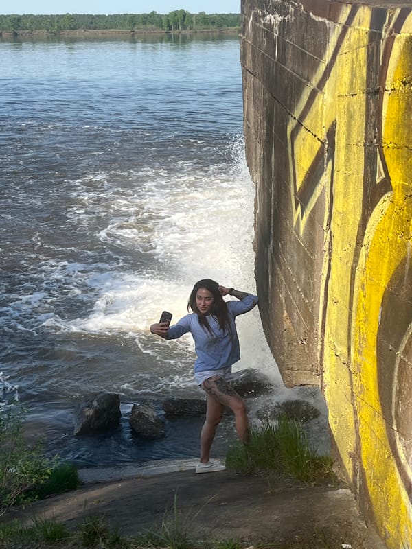 Woman takes selfies at active waterfall in Chernushka, Russia