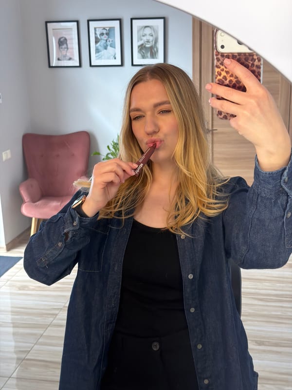 Woman applies makeup during morning routine in Riga