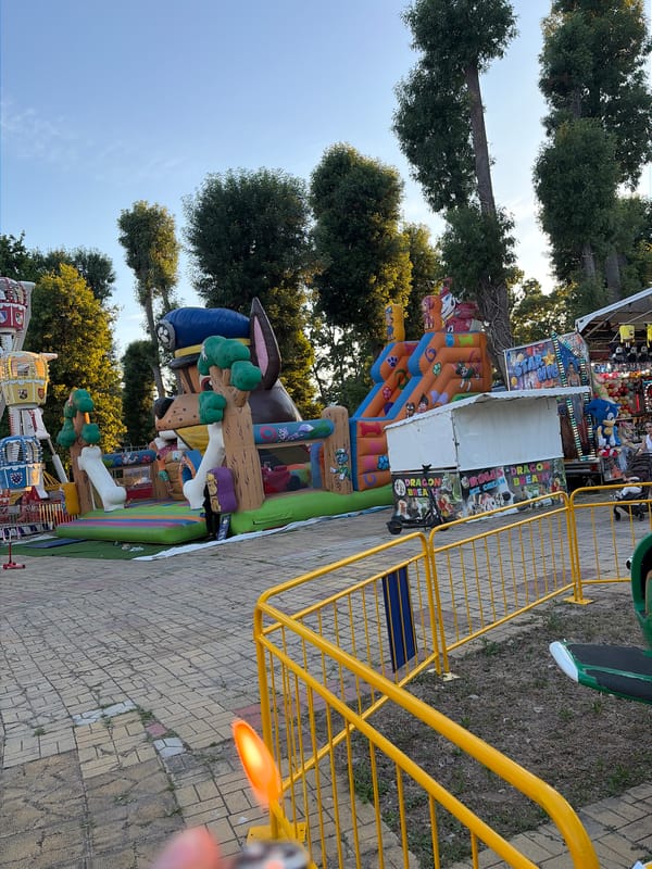 Afternoon at an outdoor carnival with rides and prize stalls