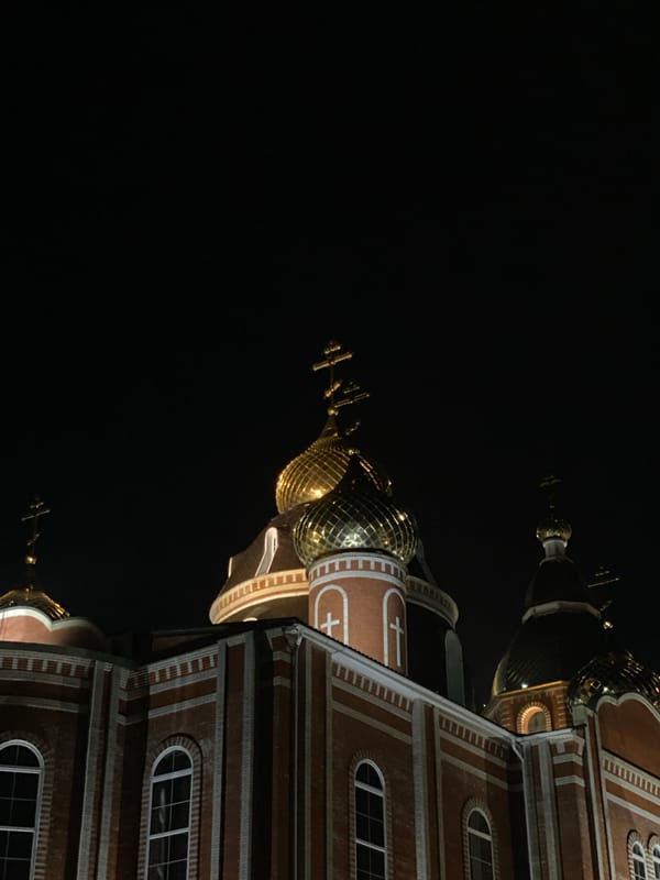 Orthodox church with golden domes observed illuminated at night