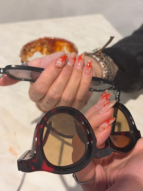 Person with decorated nails holds sunglasses in Mexico City