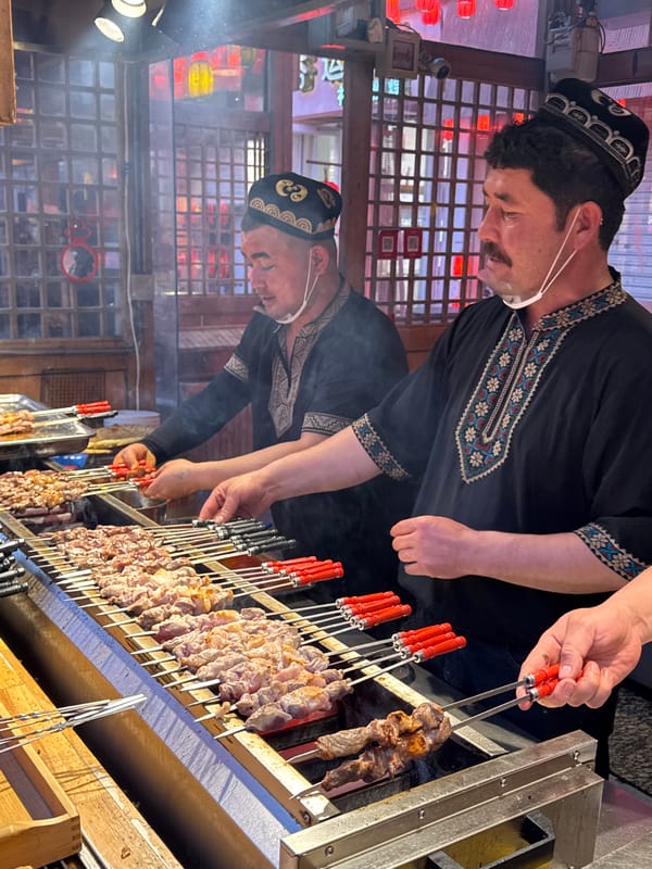 Traditional food vendors grill meat skewers in Dunhuang street market