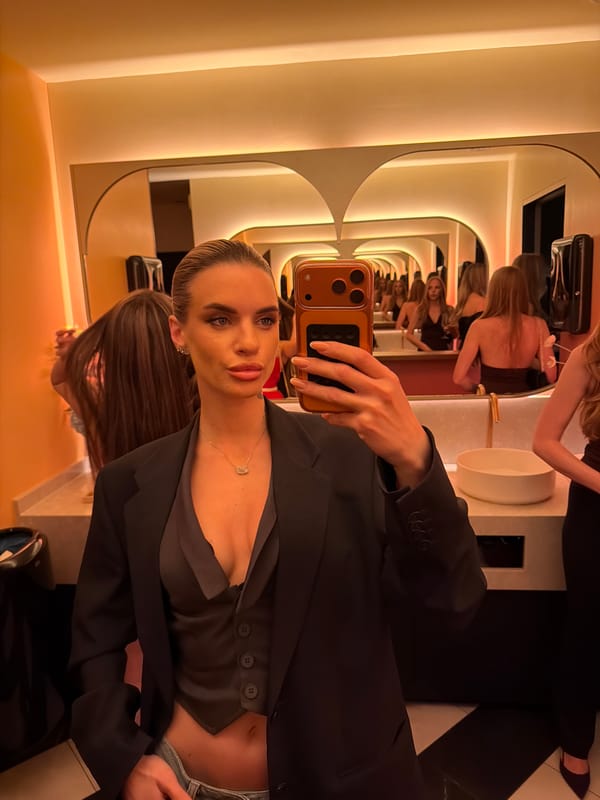 Woman takes bathroom selfie in Berlin wearing business attire