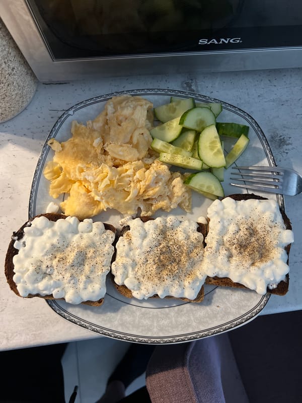 Classic Bulgarian breakfast plate with eggs, cucumber, and toast