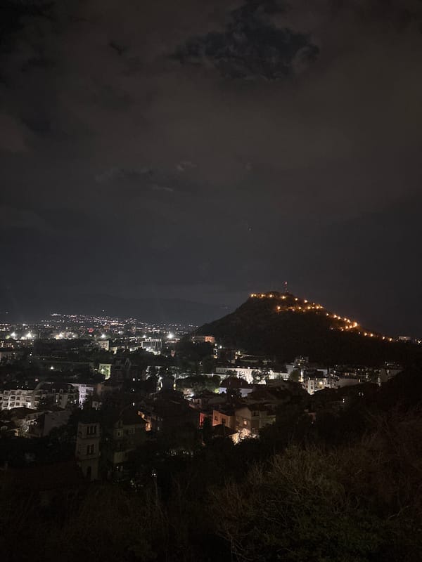 Coastal hillside town glows faintly in the night