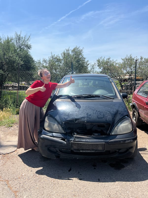 Woman stands beside heavily damaged Mercedes in Podgorica