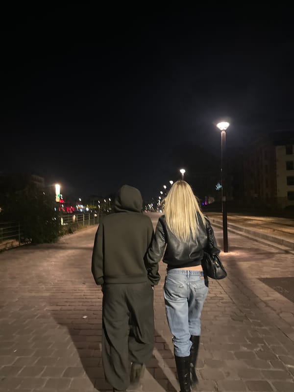 Two people walk nighttime Paris pathway near Sacré-Cœur