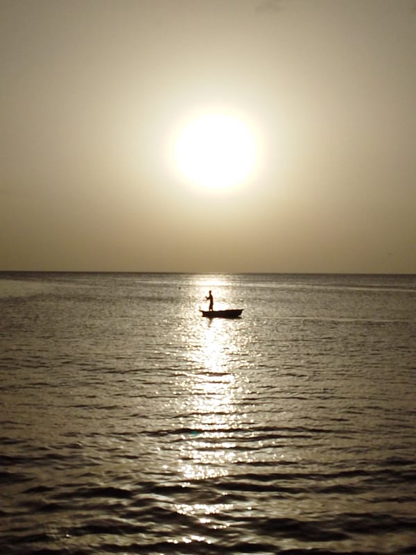 Quiet coastal sunset: boats, shoreline, and golden-hour calm
