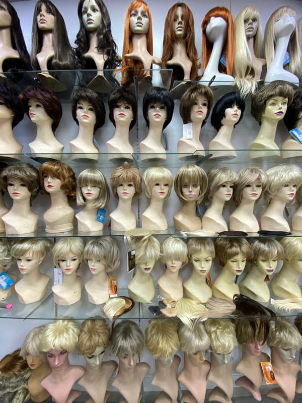 Customer tries on colorful wigs at Sochi retail shop