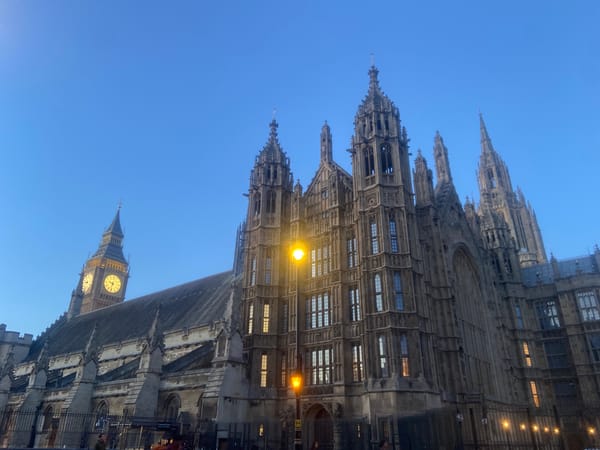 Tourist documents Westminster landmarks during London evening twilight