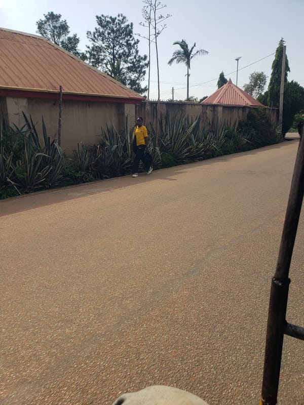 Pedestrians walk along paved road in Gura Top, Nigeria