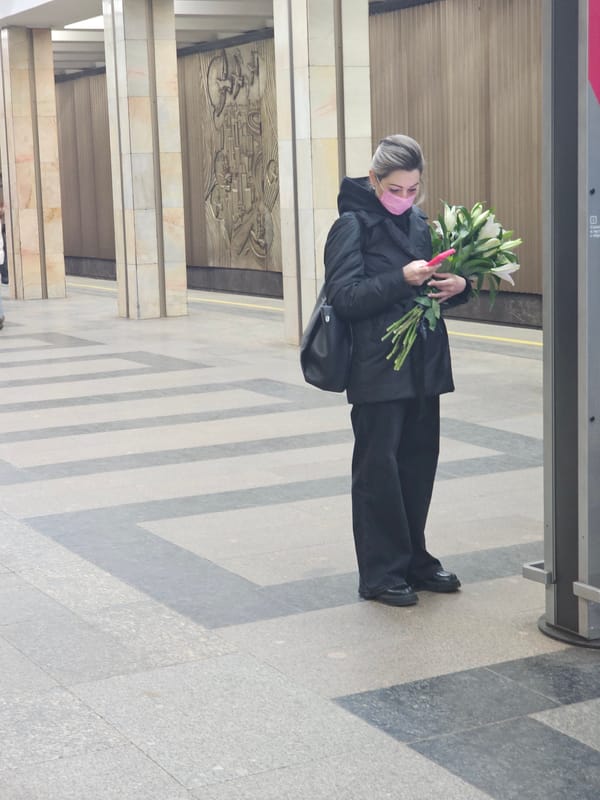 Woman with face mask holds white lily bouquet indoors
