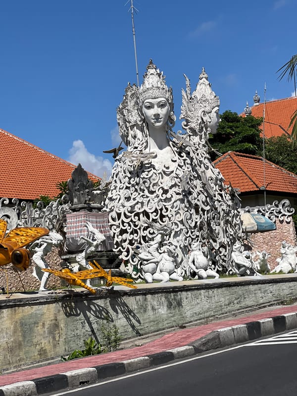 Religious statues and street activity observed in Denpasar area