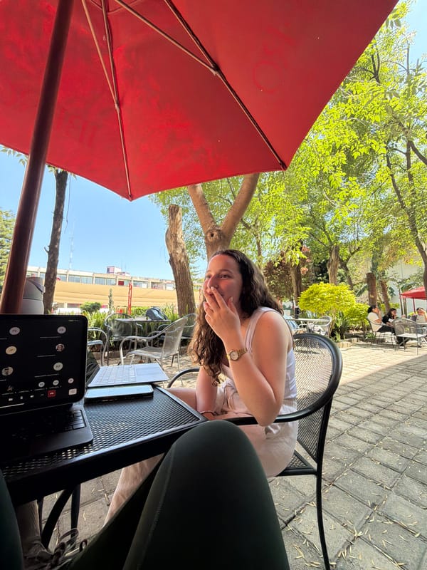 Woman at outdoor café in Tlaxcalancingo under red umbrella