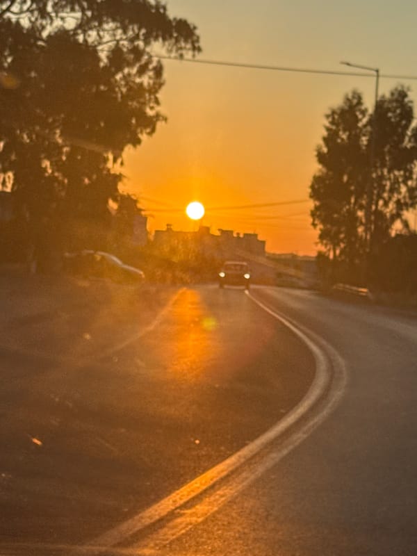 Lone car on a curved road at golden hour