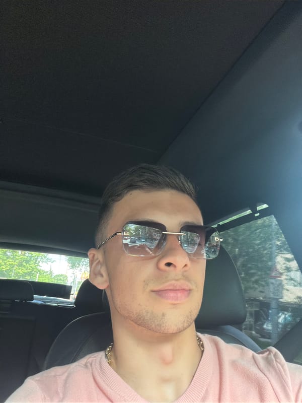 Man in pink shirt photographed inside vehicle