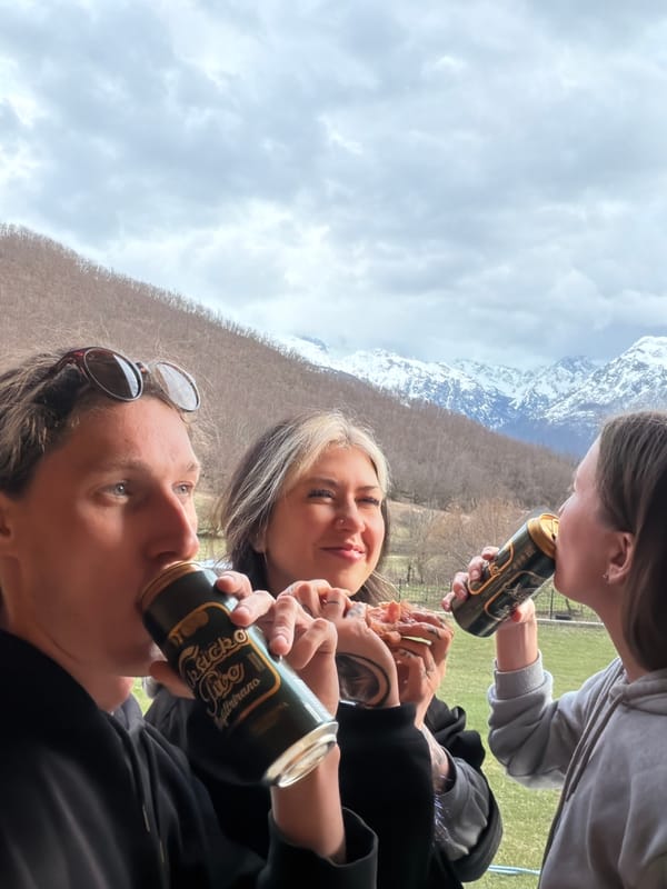 Three people share beers outdoors in Montenegro mountains