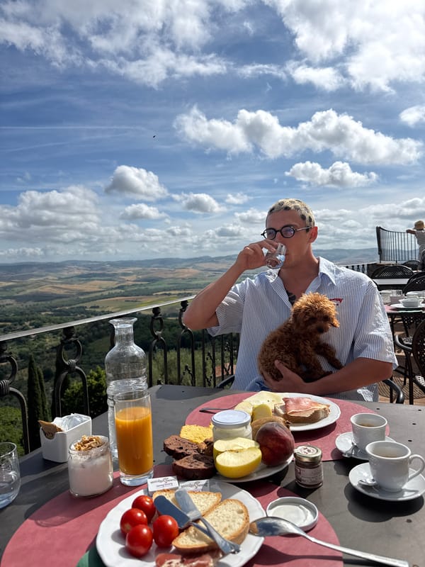 Man enjoys breakfast with poodle on Italian terrace