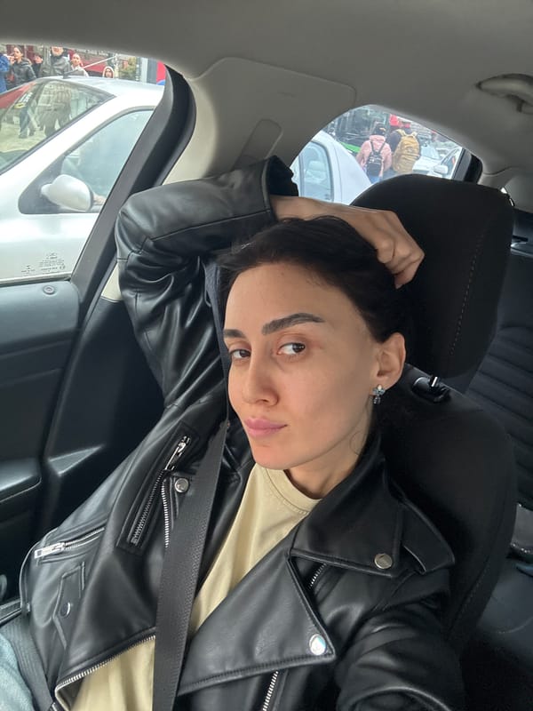 Woman takes selfies in car passenger seat in Tbilisi