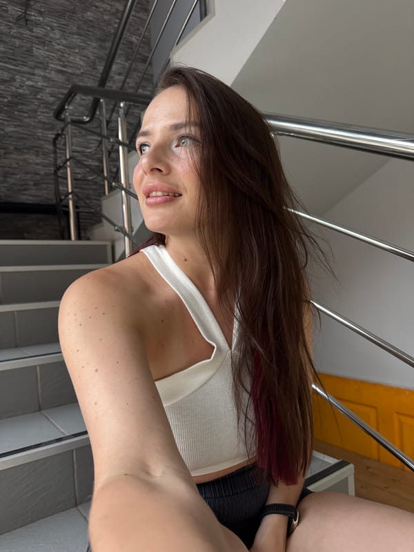 Selfie series in a grey stairwell, white top and dark shorts