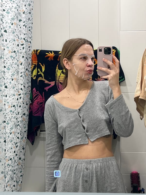Woman takes bathroom mirror selfie wearing face mask in Krasnoyarsk