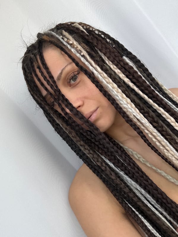Woman with braided hair photographed lying on white surface